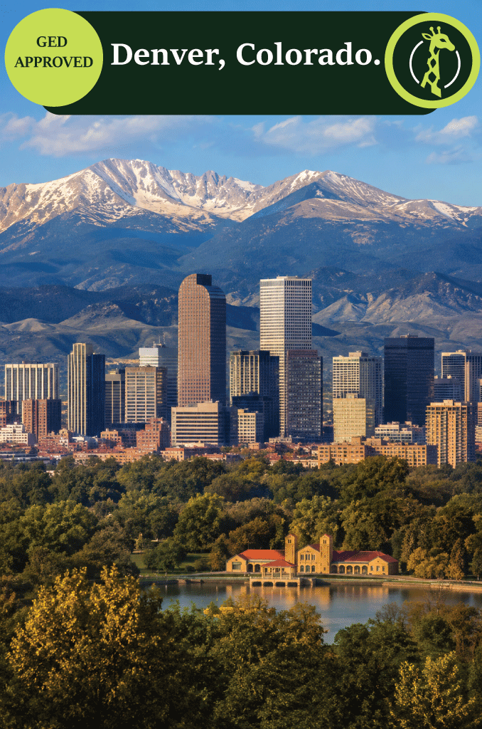 The Denver skyline at dusk with the Rocky Mountains behind it.